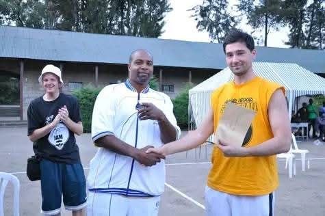 Coach Carlos presenting an award during a basketball event